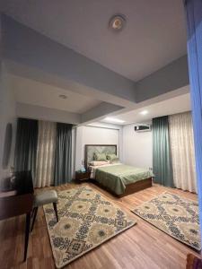 a bedroom with a bed and a table and a rug at شقه فندقيه - هلنان بورفؤاد in Port Said