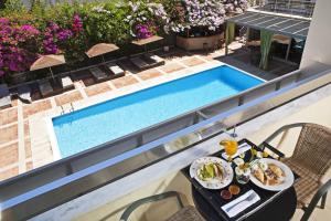 an overhead view of a table with food next to a swimming pool at Congo Palace in Athens