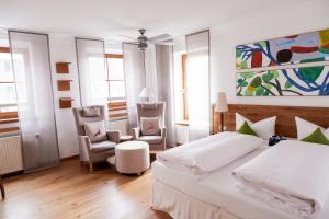 1 dormitorio con 1 cama, 2 sillas y una pintura en Romantik Hotel Hirschen, en Parsberg