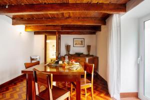 Un comedor con mesa y sillas de madera. en Mother's House, en Calheta