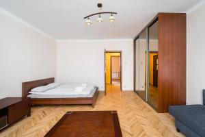 biały pokój z łóżkiem i lustrem w obiekcie Lubelska Apartment WAWELOFTS w Krakowie