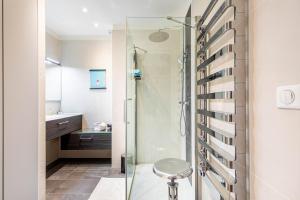 a bathroom with a shower with a stool in it at GuestReady - Modern Comfort in Vincennes in Vincennes