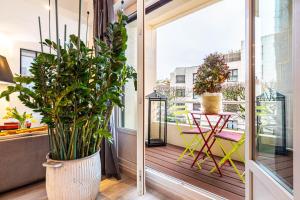een balkon met planten en een tafel en stoelen bij GuestReady - Modern Comfort in Vincennes in Vincennes