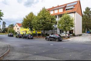 a street with cars parked in front of a building at Zentrum Kassel für 7 Personen in Kassel