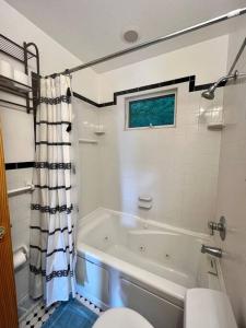 La salle de bains est pourvue d'une baignoire, de toilettes et d'une douche. dans l'établissement Candlewood Lake Retreat with year round views, à New Milford
