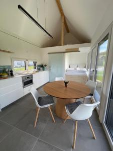 a kitchen with a table and chairs and a bed at Tinyhaus Supreme für 4 Personen in Fuchsmühl