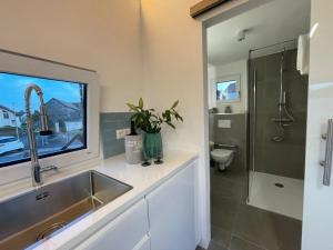 ein Bad mit einem Waschbecken, einem WC und einem Fenster in der Unterkunft Tinyhaus Supreme für 1-4 Personen in Fuchsmühl