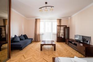 salon z niebieską kanapą i stołem w obiekcie Lubelska Apartment WAWELOFTS w Krakowie