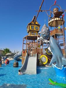 a water park with a slide and people in the water at Caesar Blue Resort & Spa 1+1 in Kalecik