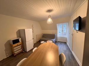 ラ・ブルブールにあるAppartement Duplex avec Wifi proche du centreのテーブルと冷蔵庫のあるリビングルーム