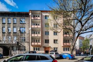 apartamentowiec z samochodami zaparkowanymi przed nim w obiekcie Lubelska Apartment WAWELOFTS w Krakowie