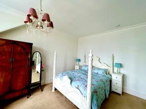 a bedroom with a bed and a mirror and a chandelier at Tigh Na Mara Guest House Rosemarkie- breakfast optional in Rosemarkie