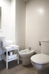 Baño blanco con aseo y lavamanos en Apartamento Labegain 3, en Sestao
