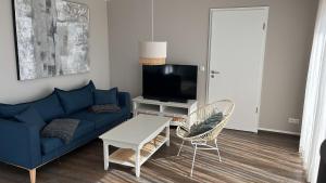 sala de estar con sofá azul y TV en Ferienhaus Eni, en Löbnitz