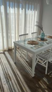 una mesa blanca con 2 sillas y una mesa de cristal en Ferienhaus Eni, en Löbnitz