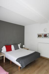 een slaapkamer met een wit bed en een grijze muur bij Apartamento Labegain 3 in Sestao