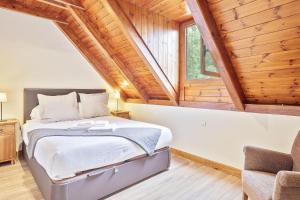 a bedroom with a bed in a room with wooden ceilings at Luderna - Casa con jardín Vista Aneto in Vilamós