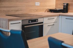 a kitchen with a stove and a wooden counter top at Apartma Ksenija in Črniče +11 photos