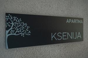 un panneau sur un mur avec un arbre sur celui-ci dans l'établissement Apartma Ksenija, à Črniče
