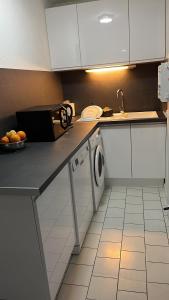 a kitchen with white cabinets and a dishwasher at LOCATION CAP D'AGDE in Cap d'Agde