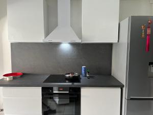 a kitchen with white cabinets and a black counter top at LOCATION CAP D'AGDE in Cap d'Agde