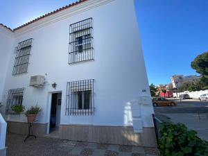 ein weißes Gebäude mit drei Fenstern und einer Tür in der Unterkunft Apartamento Crucero 2, la Jara in Sanlúcar de Barrameda