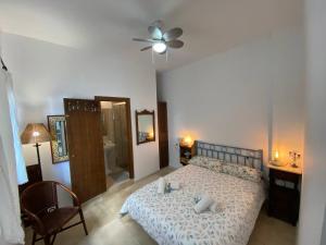 ein Schlafzimmer mit einem Bett und einem Deckenventilator in der Unterkunft Apartamento Crucero 2, la Jara in Sanlúcar de Barrameda