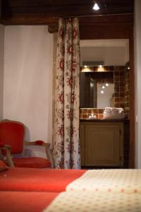a bedroom with a bed and a bathroom with a mirror at Le Castellas Hotel & SPA - TERITORIA in Collias