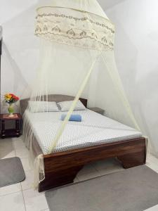 a bed with a net on top of it at Sanaa Hostel in Zanzibar City