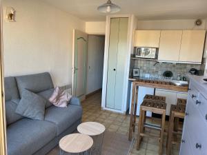 a living room with a couch and a kitchen at Saint clair in Le Lavandou