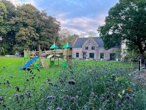 a playground in front of a house with a building at Vakantiewoning Domein Hooverbosch in Zonnebeke