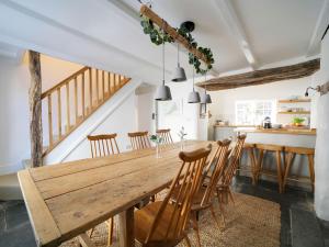 a kitchen and dining room with a wooden table and chairs at Bell Cottage in Saint Teath