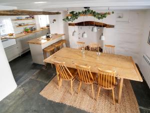 a dining room with a wooden table and chairs at Bell Cottage in Saint Teath