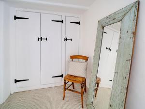 a chair in a room with a mirror at Bell Cottage in Saint Teath