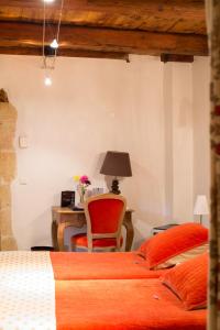 a bedroom with two beds and a desk with a chair at Le Castellas Hotel & SPA - TERITORIA in Collias