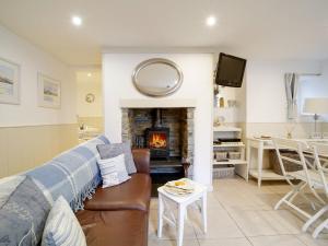 a living room with a couch and a fireplace at Bosuns Locker in Port Isaac