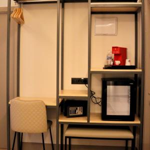 um quarto com uma secretária, um micro-ondas e uma cadeira em Hostal La Rúa-Montera em Madri