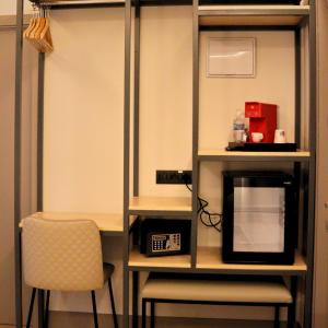 a room with a desk with a microwave and a chair at Pensión La Rúa-Montera in Madrid +15 photos
