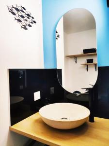 La salle de bains est pourvue d'un lavabo et d'un miroir. dans l'établissement Joli appartement aux Minimes avec Parking, à La Rochelle