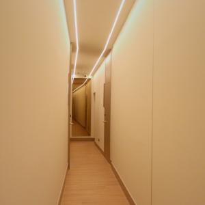 a hallway with a long corridor with white walls and wooden floors at Hostal La Rúa-Montera in Madrid