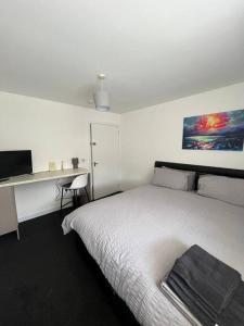 a bedroom with a bed and a desk with a computer at The M Rooms in Kirk of Shotts