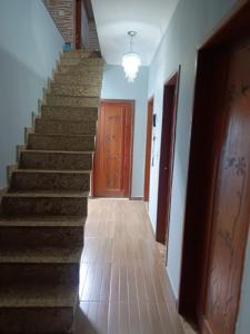 einen leeren Flur mit Treppen und Holztüren in der Unterkunft Residence Alto Padrão in Itaboraí