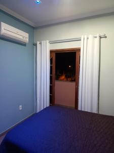 ein leeres Zimmer mit einem Bett und einem Fenster in der Unterkunft Residence Alto Padrão in Itaboraí