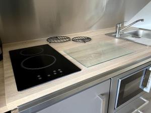 a kitchen counter with a stove and a sink at Little studio annexe in Marlow