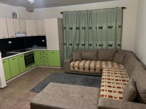 Il comprend un salon avec un canapé et une cuisine. dans l'établissement Anisa appartament, à Durrës