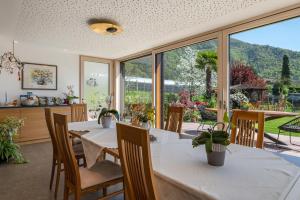 uma sala de jantar com mesa e cadeiras e uma grande janela em Haus Rosengarten Apt A em Terlano