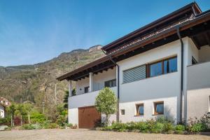 uma casa com uma montanha ao fundo em Haus Rosengarten Apt A em Terlano