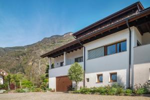 a house with a mountain in the background at Haus Rosengarten Apt B in Terlano