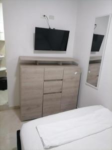 um quarto com uma televisão em cima de uma cómoda em Hostel HA em Cartagena das Índias