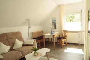 uma sala de estar com um sofá e uma mesa em Ferienhaus Berghaus em Norderney
